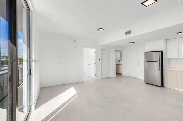 an empty room with floor to ceiling window and closet