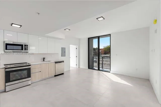 a view of a kitchen with a sink and white cabinets