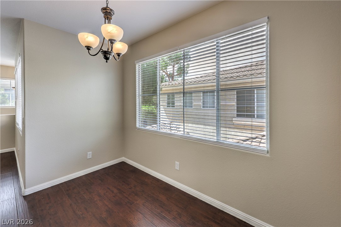 9050 West Warm Springs Road, Unit 2033 Las Vegas, NV 89148 - Photo 14 of 30 Rich hardwood flooring and a stylish chandelier define this inviting dining space.