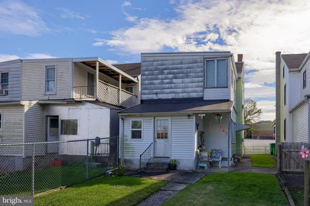 a view of a house with a yard and sitting area