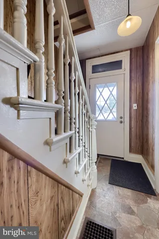 a view of staircase with railing and a chandelier