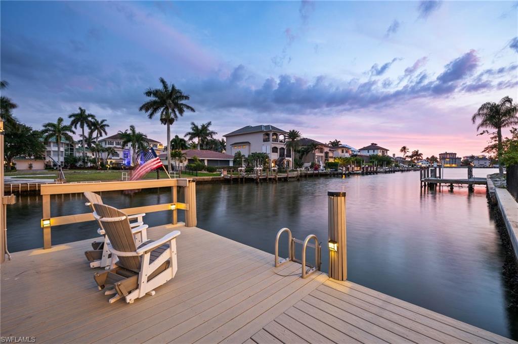 388 Pine Avenue Naples, FL 34108 - Photo 2 of 34 a view of a lake with a table and chairs
