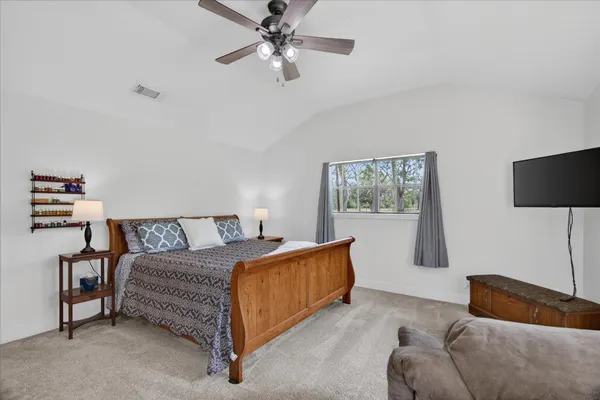 a bedroom with a bed lamp and a window