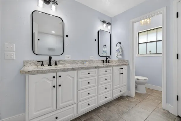 a bathroom with double sink and a mirror
