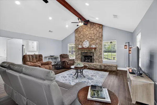 a living room with furniture a fireplace and a flat screen tv