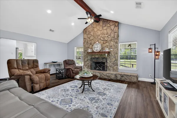 a living room with furniture a fireplace and a flat screen tv