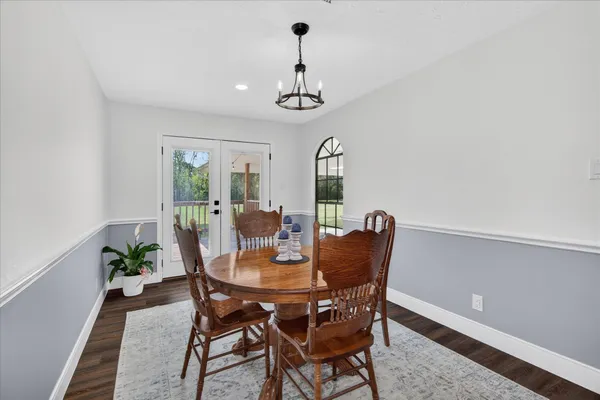 a dining room with furniture a rug and a chandelier