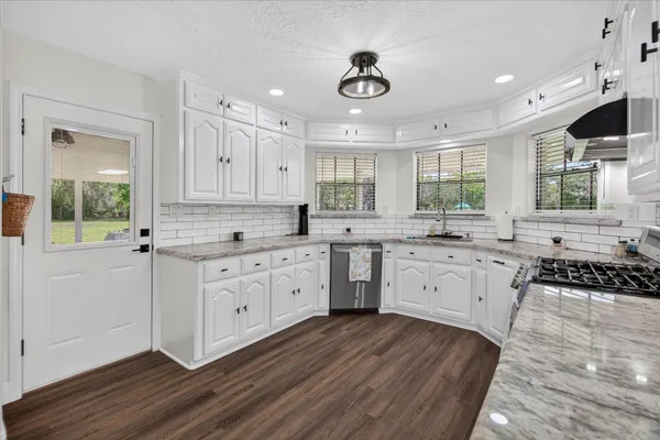a kitchen with a sink window and cabinets