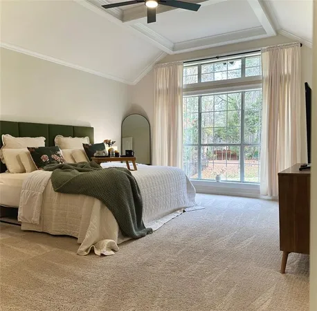 a spacious bedroom with a bed a lamp and a large window with outer view