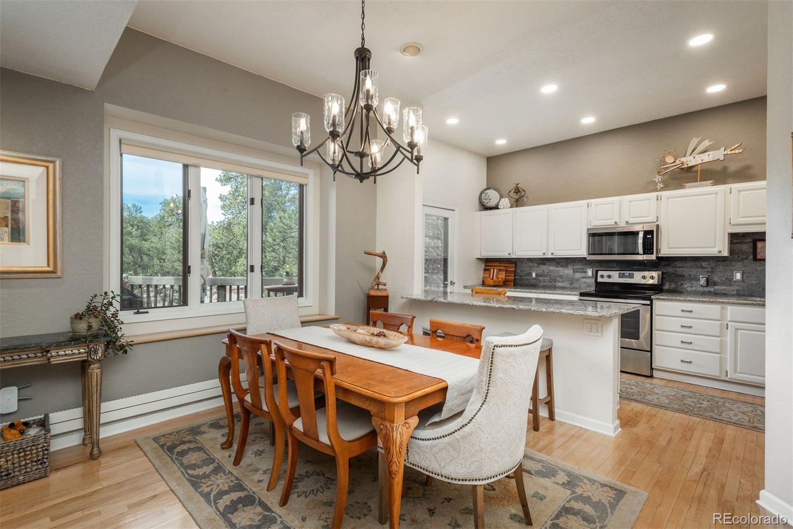 4192 Timbervale Drive Evergreen, CO 80439 - Photo 11 of 50 a dining room filled chandelier and kitchen view