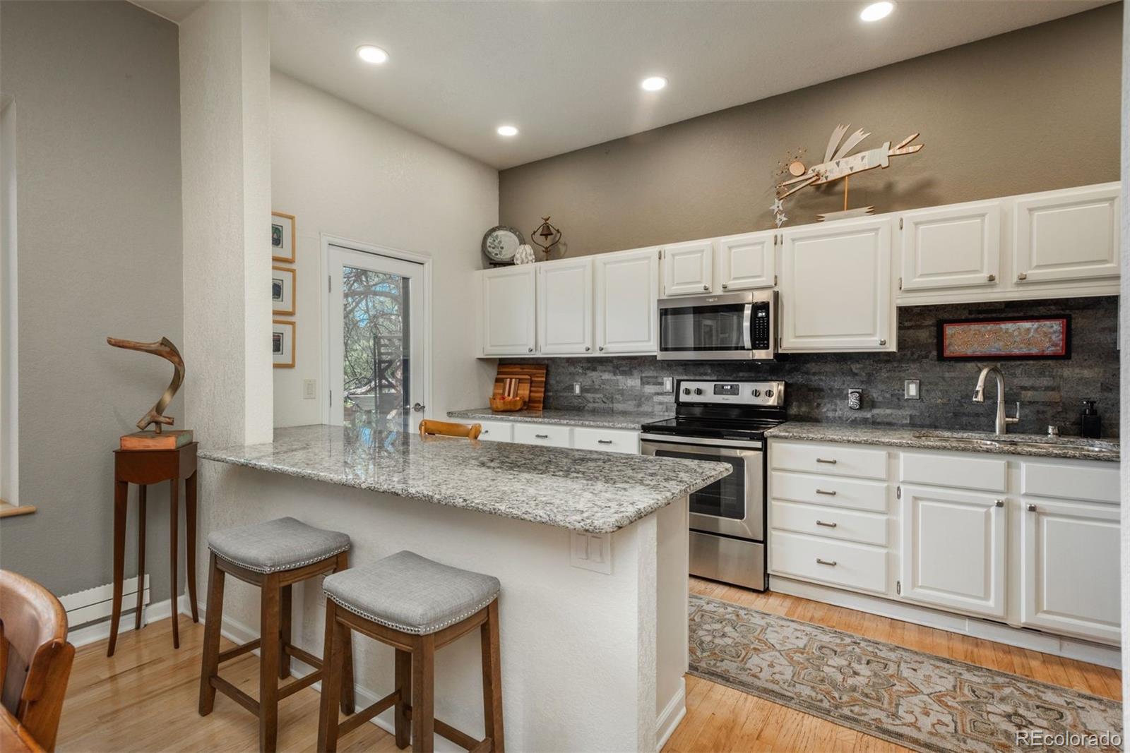 4192 Timbervale Drive Evergreen, CO 80439 - Photo 12 of 50 a kitchen with stainless steel appliances granite countertop a stove top oven a sink a microwave and a refrigerator