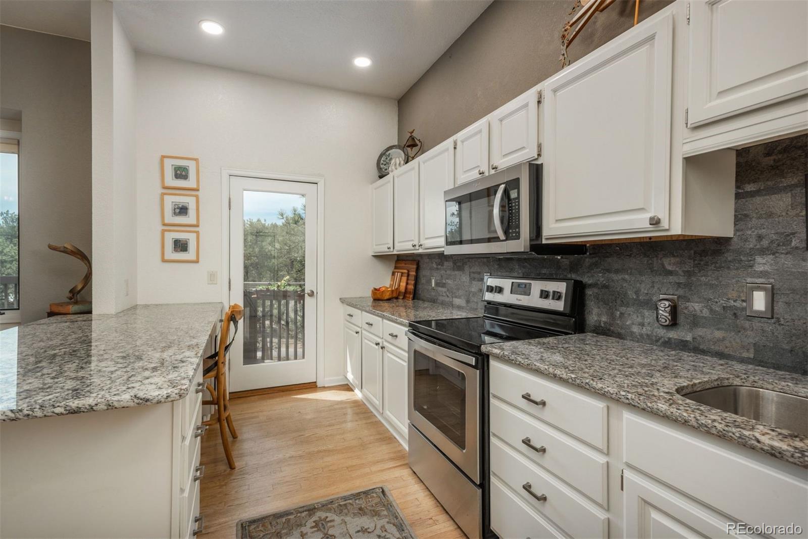 4192 Timbervale Drive Evergreen, CO 80439 - Photo 13 of 50 a kitchen with stainless steel appliances granite countertop a stove a sink and a granite counter tops