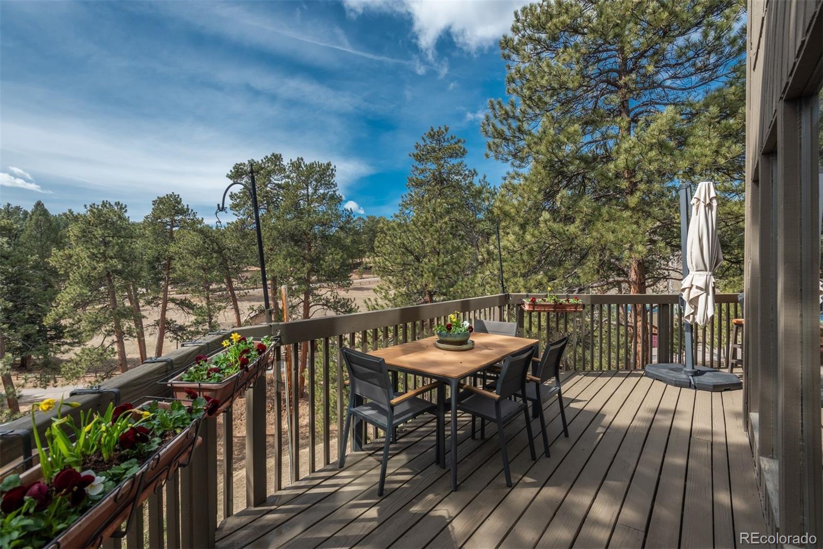 4192 Timbervale Drive Evergreen, CO 80439 - Photo 16 of 50 a balcony with wooden floor and outdoor seating