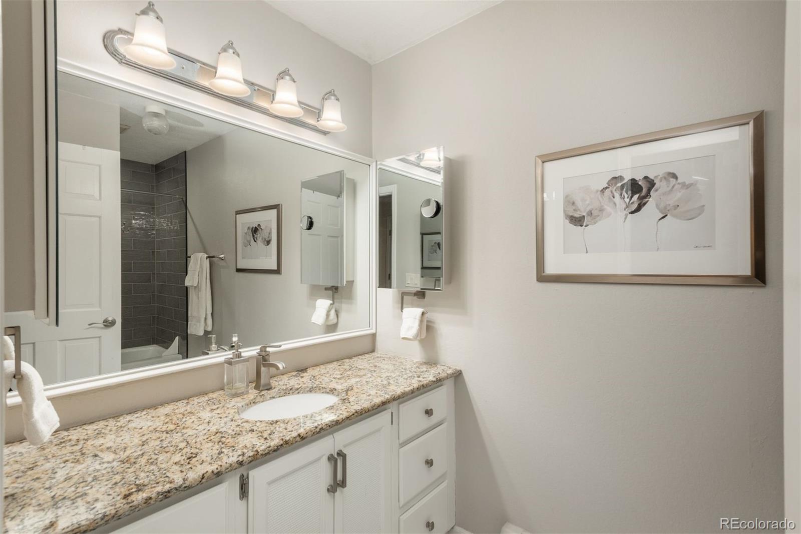 4192 Timbervale Drive Evergreen, CO 80439 - Photo 45 of 50 a bathroom with a granite countertop double vanity sink and a mirror