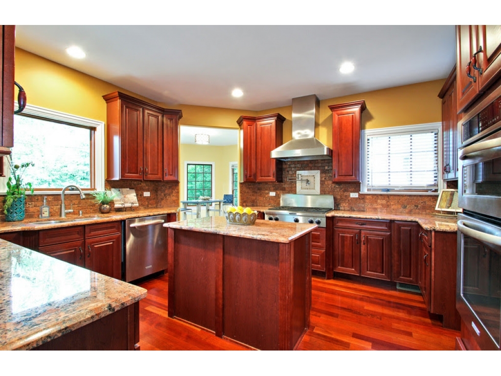 713 Greenwood Road Glenview, IL 60025 - Photo 4 of 11 a kitchen with stainless steel appliances granite countertop wooden cabinets a stove a sink and a large window