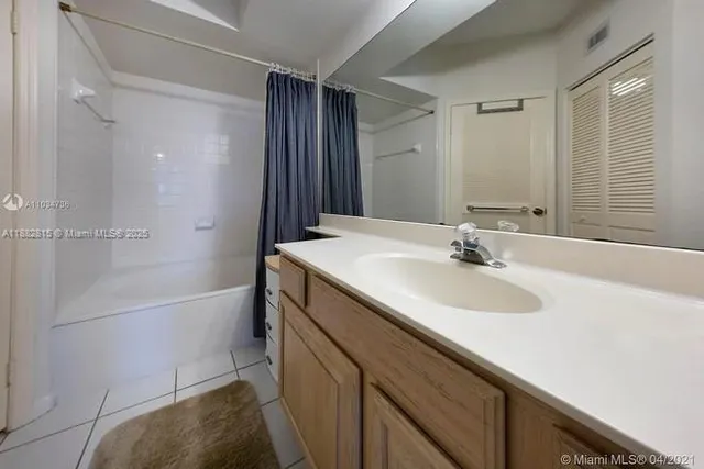 a bathroom with a sink double vanity mirror and a bathtub