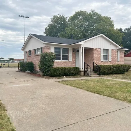 a front view of a house with a yard and trees