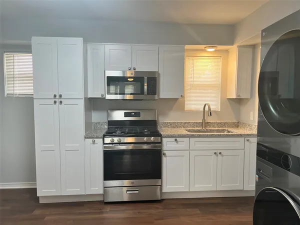 a kitchen with stainless steel appliances a stove a sink and a microwave