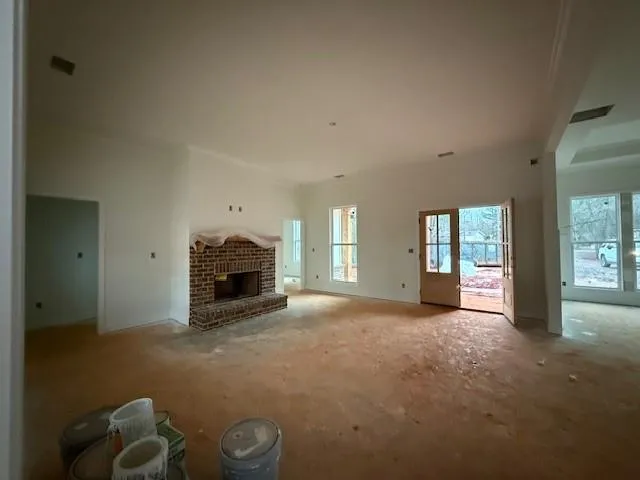 an empty room with windows and fireplace