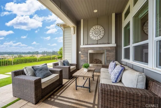 a living room with furniture a fireplace and a floor to ceiling window