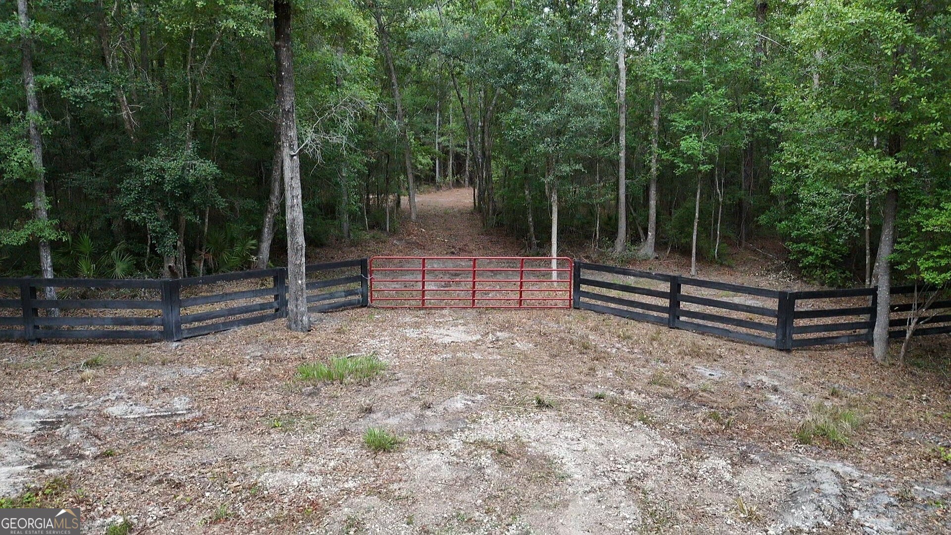 Lot 8 Emmaus Church Road St. George, GA 31562 - Photo 2 of 10 a backyard of a house with lots of green space and wooden fence