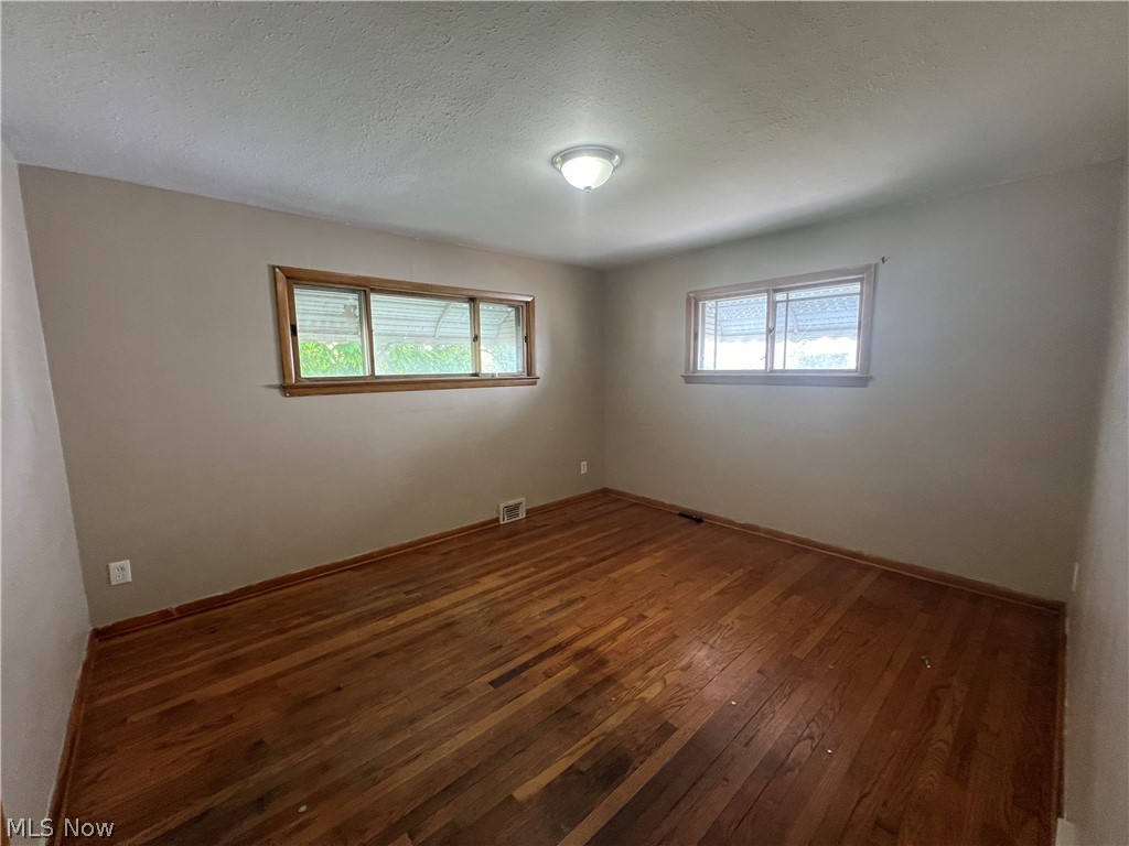 20731 Donnybrook Road Maple Heights, OH 44137 - Photo 6 of 17 Empty room with a textured ceiling and hardwood / wood-style floors