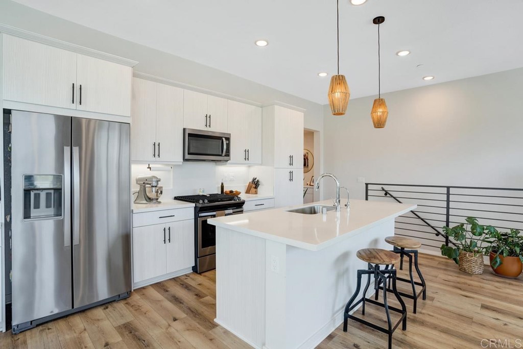 2048 Bravo Loop, Unit 2 Chula Vista, CA 91915 - Photo 6 of 34 a kitchen with kitchen island white cabinets and stainless steel appliances