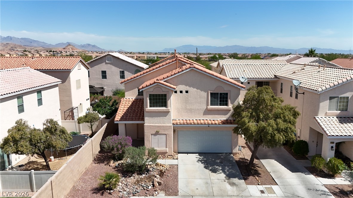 8934 Deep Ridge Court Las Vegas, NV 89178 - Photo 31 of 47 A terracotta-tiled roof crowns this residence, featuring a two-car garage and manicured front yard landscaping.