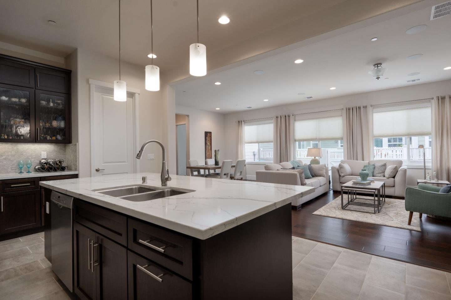 18527 McClellan Circle Marina, CA 93933 - Photo 7 of 35 a kitchen with center island a sink dishwasher a stove and a dining table with wooden floor