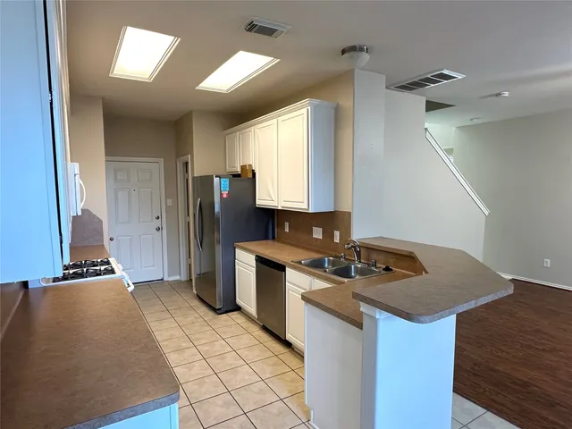a kitchen that has a sink a stove and a refrigerator