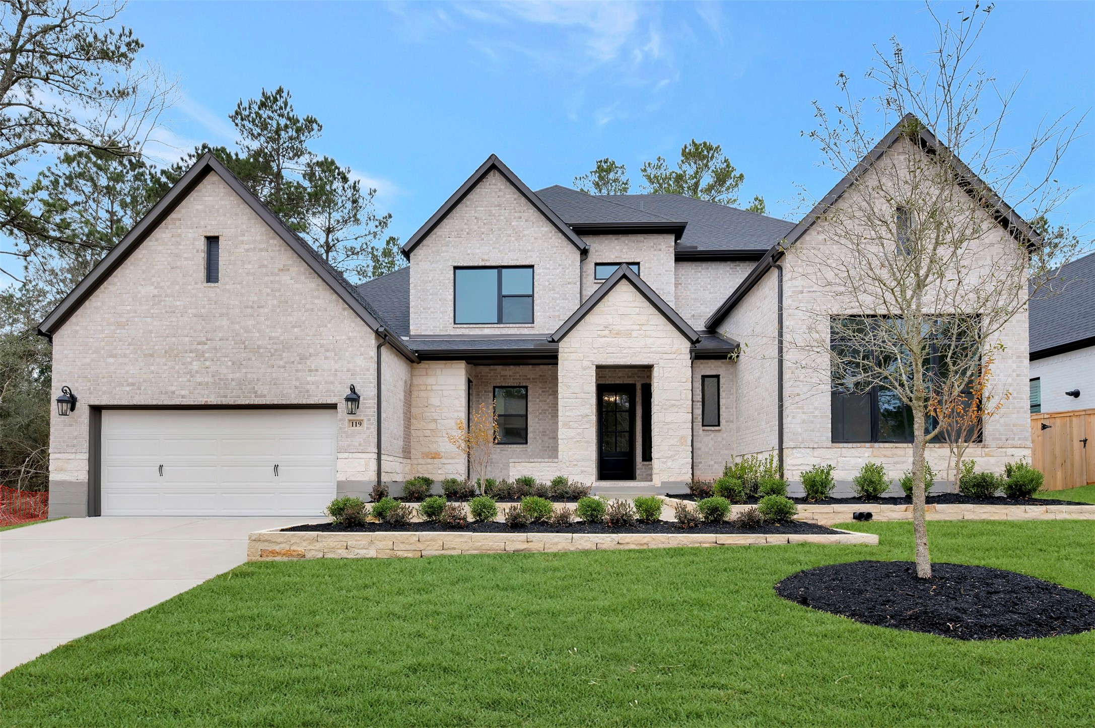 119 Rustica Bloom Trail Willis, TX 77318 - Photo 2 of 50 a front view of a house with a garden and plants