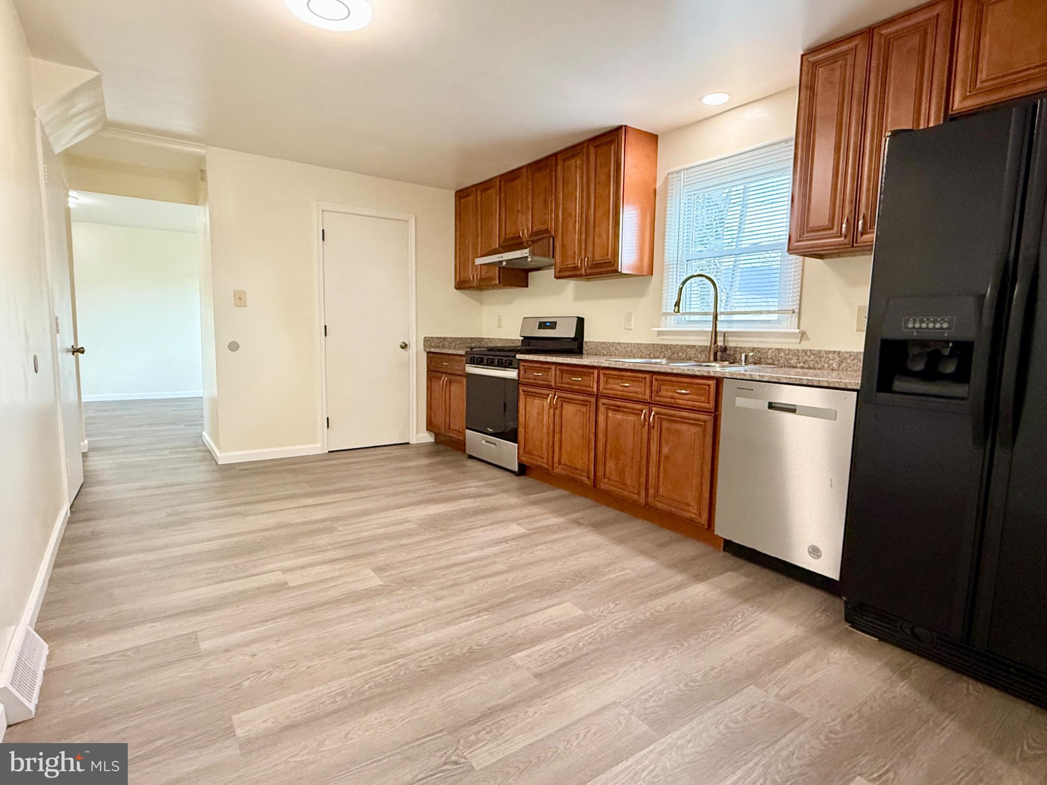 303 Oregon Avenue New Castle, DE 19720 - Photo 12 of 40 a kitchen with stainless steel appliances granite countertop a refrigerator a stove top oven a sink and dishwasher
