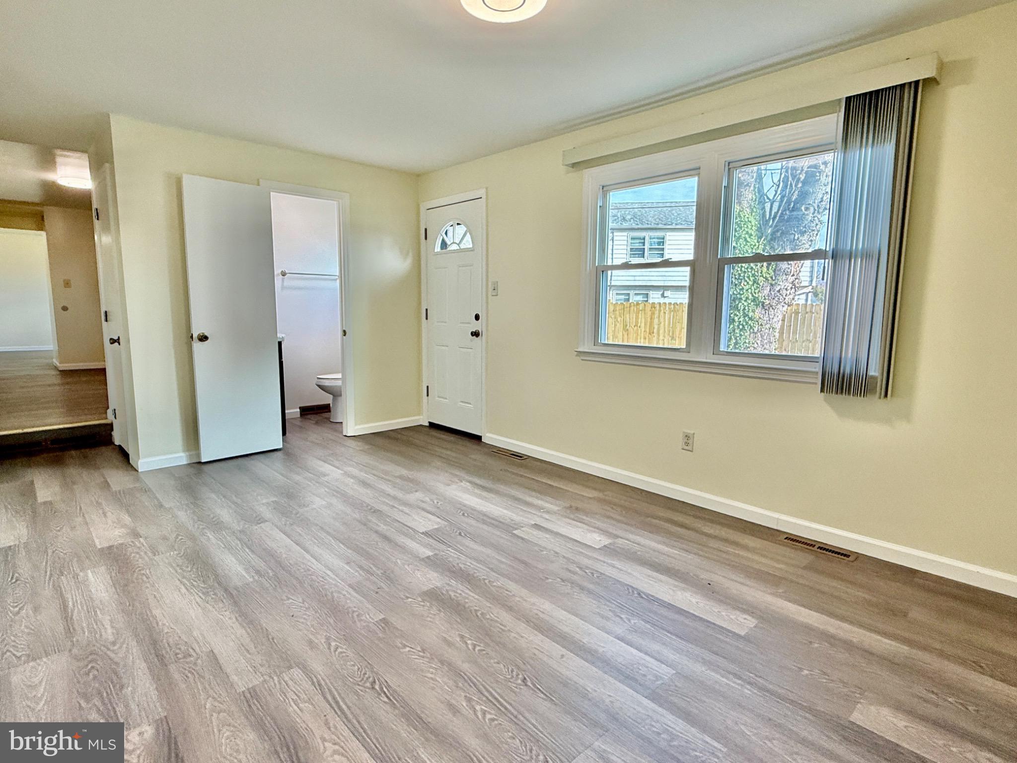 303 Oregon Avenue New Castle, DE 19720 - Photo 15 of 40 a view of an empty room with wooden floor and a window