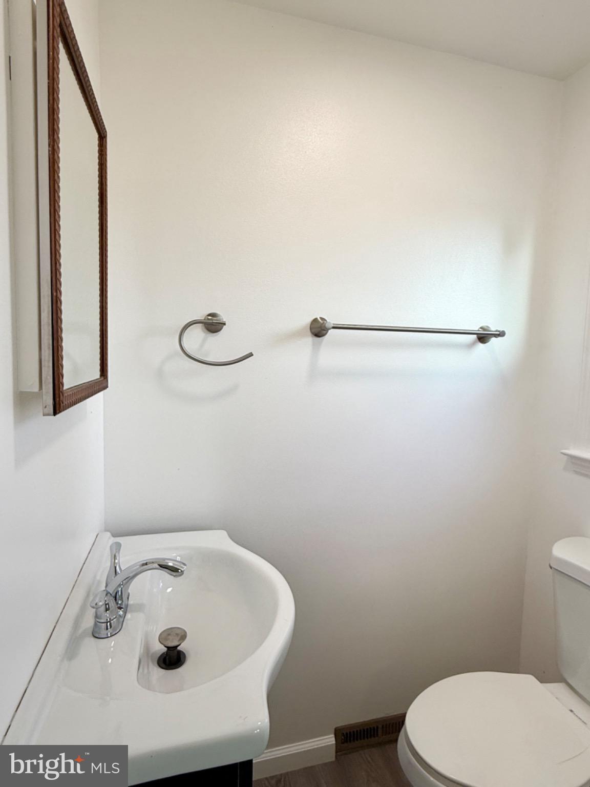 303 Oregon Avenue New Castle, DE 19720 - Photo 17 of 40 a bathroom with a sink a toilet and mirror