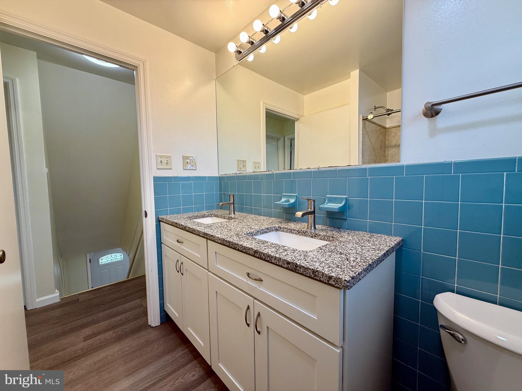 303 Oregon Avenue New Castle, DE 19720 - Photo 21 of 40 a bathroom with a granite countertop sink a toilet and a mirror