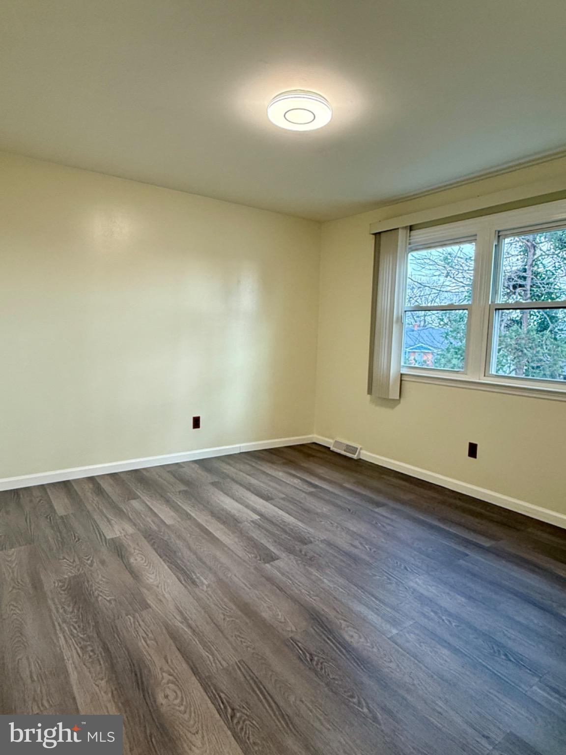 303 Oregon Avenue New Castle, DE 19720 - Photo 27 of 40 an empty room with wooden floor and windows