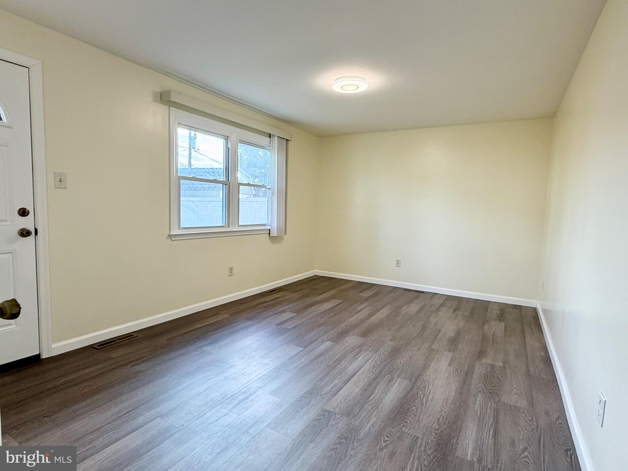 303 Oregon Avenue New Castle, DE 19720 - Photo 34 of 40 an empty room with wooden floor and windows