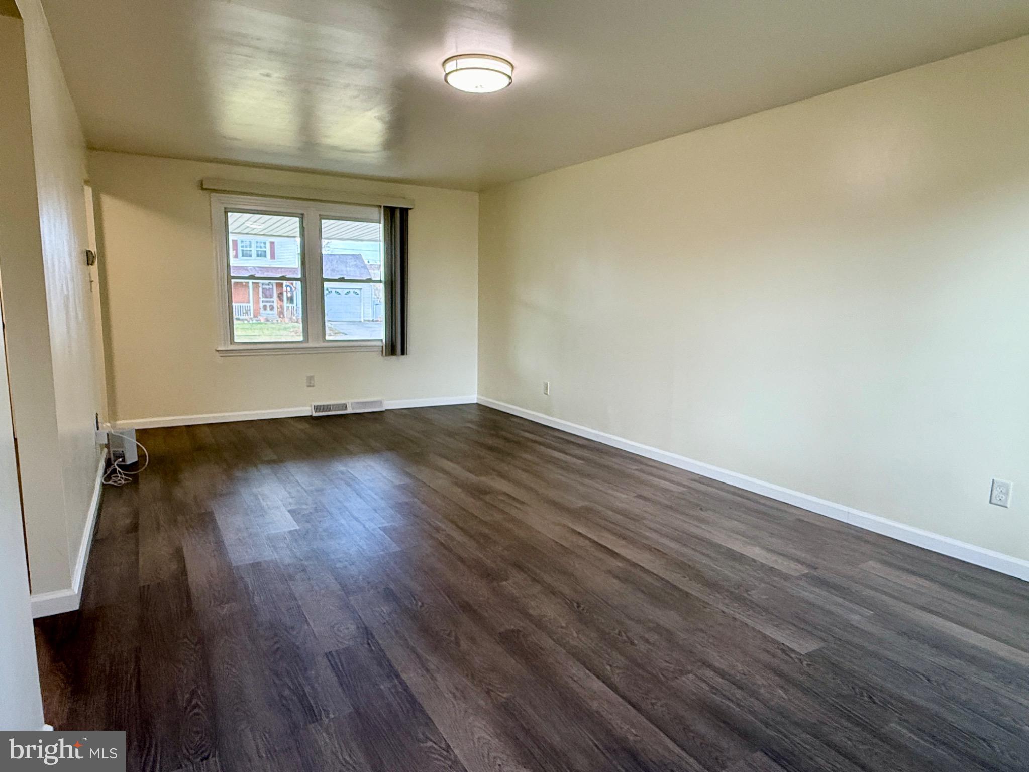 303 Oregon Avenue New Castle, DE 19720 - Photo 35 of 40 an empty room with wooden floor and windows