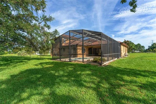 an empty room with chandelier fan and windows
