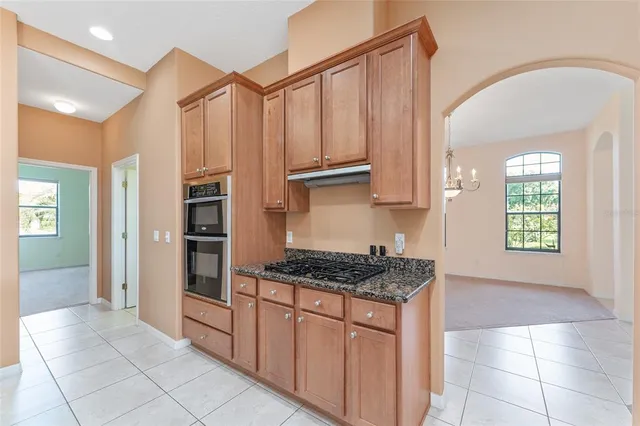 a kitchen with stainless steel appliances granite countertop white cabinets and a refrigerator