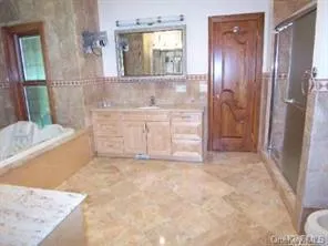 a bathroom with a granite countertop sink a mirror and a bathtub