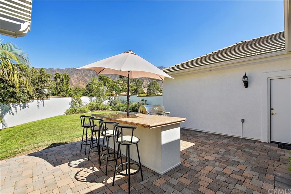 2432 Prospect Drive Upland, CA 91784 - Photo 30 of 46 a view of a patio with table and chairs under an umbrella