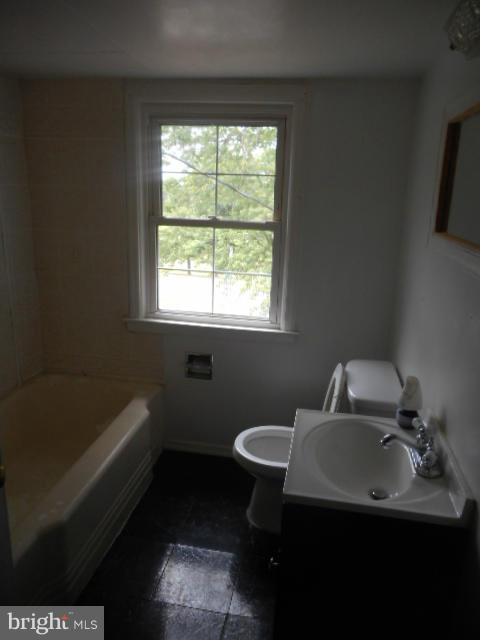 6313 Fieldvale Road Baltimore, MD 21237 - Photo 16 of 30 a bathroom with a sink toilet a tub and a window