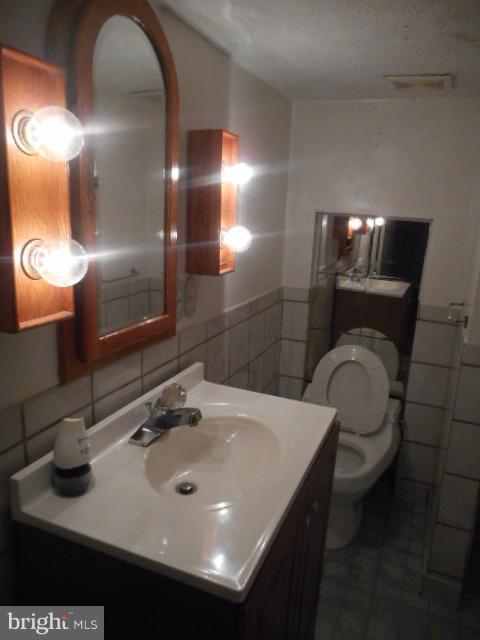 6313 Fieldvale Road Baltimore, MD 21237 - Photo 22 of 30 a bathroom with a sink a toilet and mirror