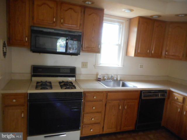 6313 Fieldvale Road Baltimore, MD 21237 - Photo 6 of 30 a kitchen with a sink stove and microwave