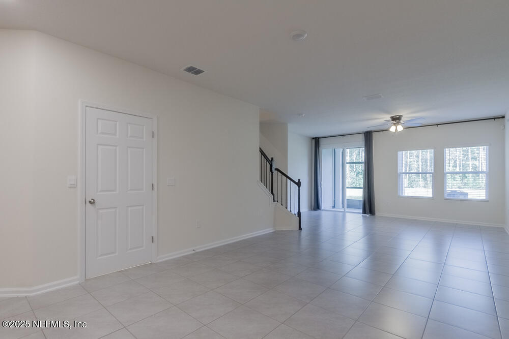 97 Coastline Way Street St. Augustine, FL 32092 - Photo 4 of 31 a view of an empty room with a window and wooden floor