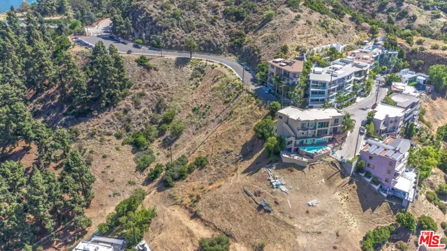 a balcony with table and chairs and potted plants
