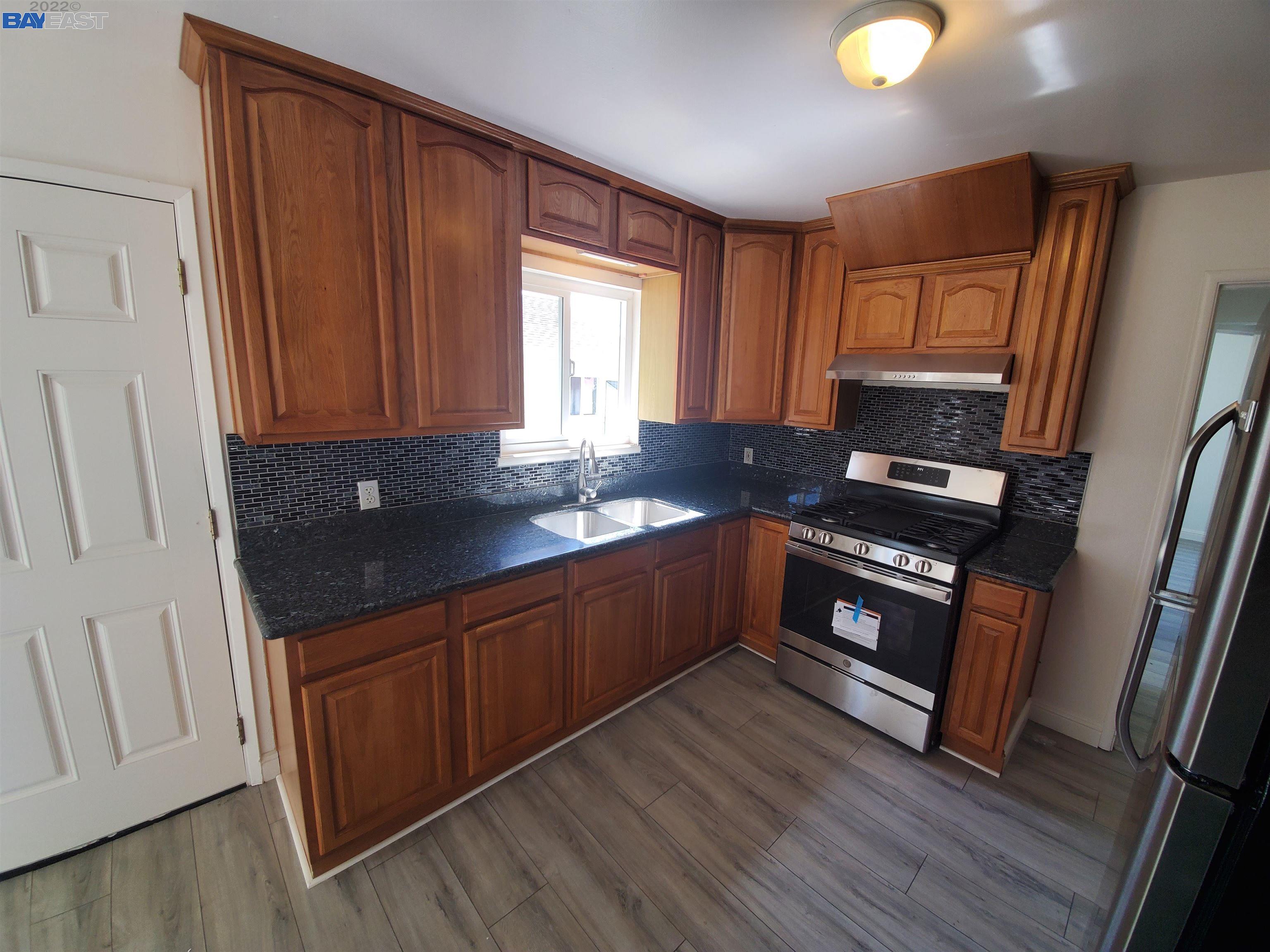 1869 E Street Hayward, CA 94541 - Photo 14 of 22 a kitchen with granite countertop wooden cabinets and a stove top oven