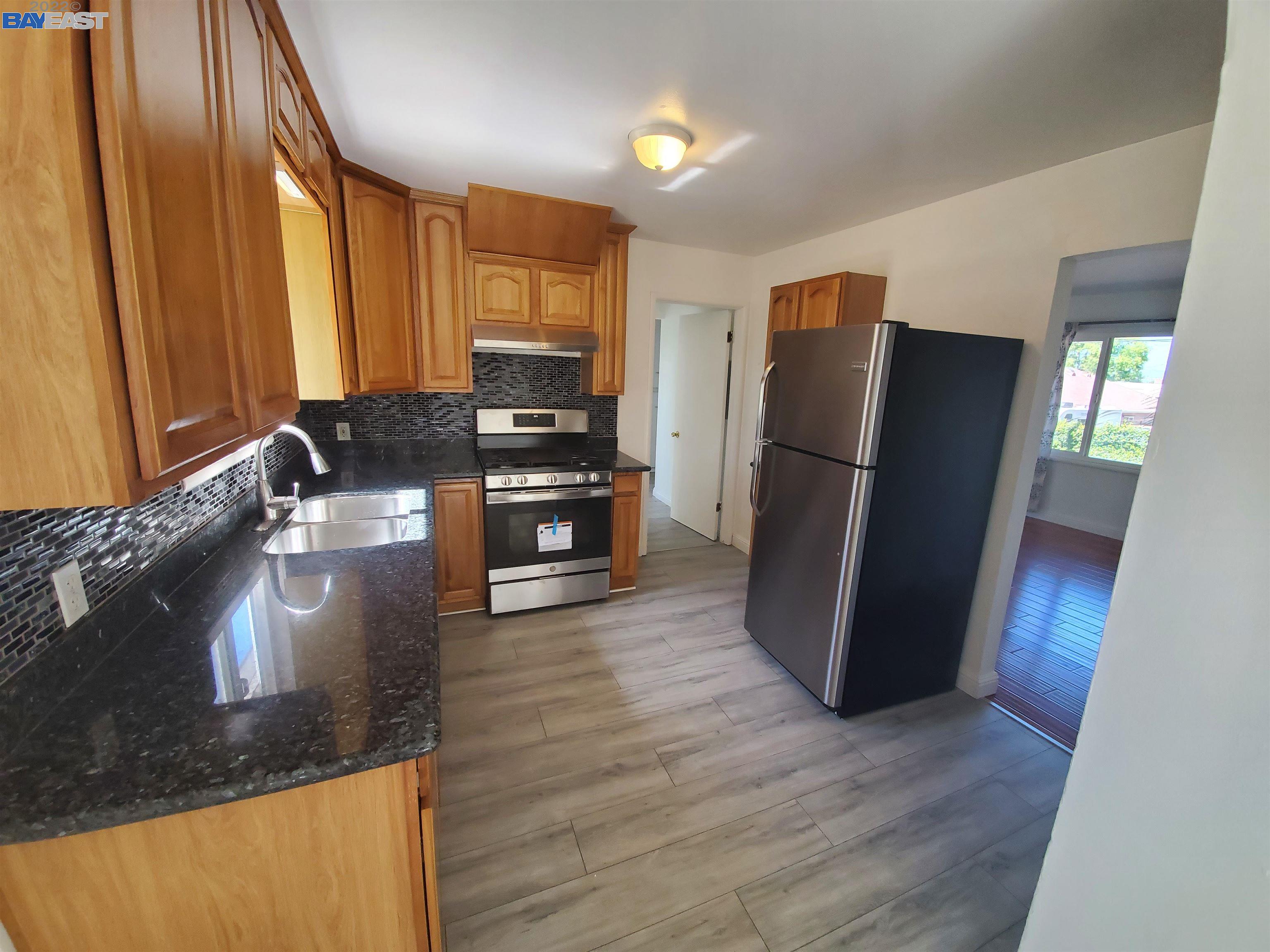 1869 E Street Hayward, CA 94541 - Photo 16 of 22 a kitchen with stainless steel appliances granite countertop a refrigerator a stove and a wooden floor