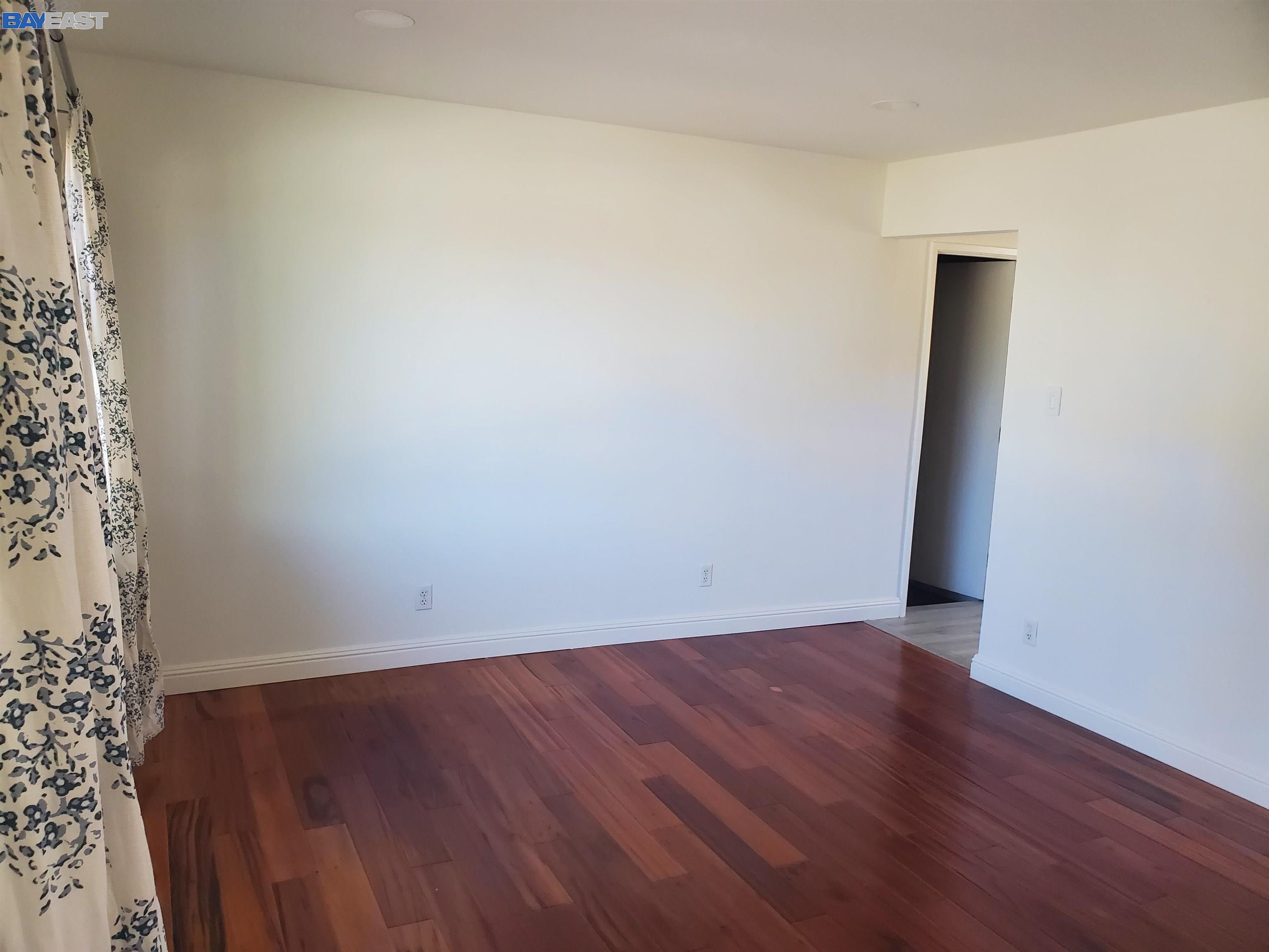 1869 E Street Hayward, CA 94541 - Photo 3 of 22 an empty room with wooden floor and a window